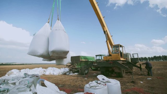 Chemical Fertilize. Agricultural crane lifts fertilizer bags