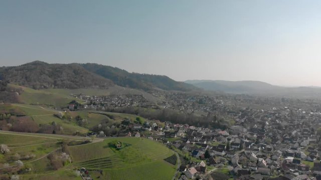 Aerial view of a village with forest and mountains in background