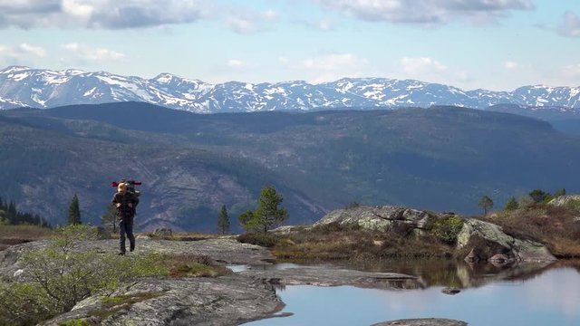 Person hiking alone in spectacular surroundings in the mountains with snowy mountains in the background