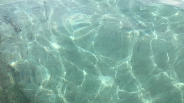 Time lapse of bright white underwater background with sunlight water ripples and white sand floor in Mediterranean sea