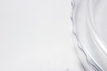 Fototapeta na wymiar Fundo branco com pequeno detalhe de peça de acrílico ondulada ao lado
