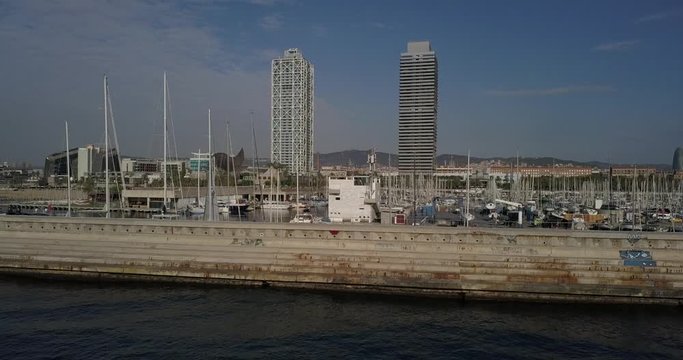 Aerial dolly backwards Port Olimpic Escullera del Poblenou and Mapfre Tower
