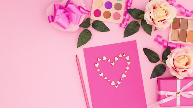 Little harts make big heart on pink paper with romantic floral decoration - Sop motion