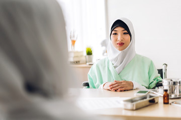 Muslim asian woman doctor service help support discussing and consulting talk to muslim woman patient and check up information at meeting health medical care express trust concept in hospital