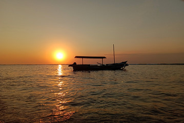 Fototapeta na wymiar boat with the sunset on the beach