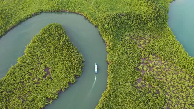 2020 - amazing top down aerial over small boat moving along the Gambia river in West Africa.