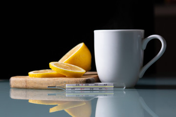 the thermometer with a cup of tea and lemon
