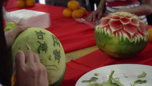 Woman Carving Chinese Texts into Watermelon at Buddhist Temple