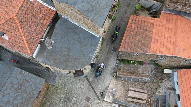 Drone Top View over rival village with motorcycles passing by