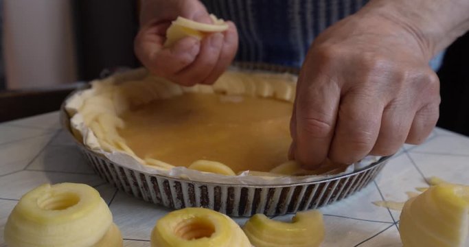 close up on senior man hands making an apple pie, low angle