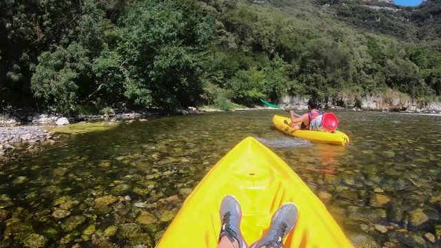 two man on canoe going down a narrow river stream in national park