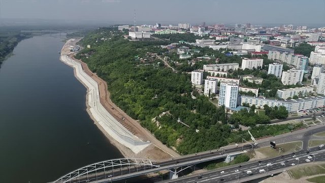 Quadcopter flies over the city through the river and the bridge