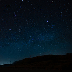 Fototapeta premium Starry sky on a background of a slope, night landscape. Astrology, horoscopes, astro screensaver, space