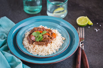 A plate of homemade Beef stew on rice with capsicum and coriander 