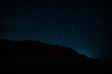 Naklejka na ściany i meble Night landscape with starry sky. Astrology, space