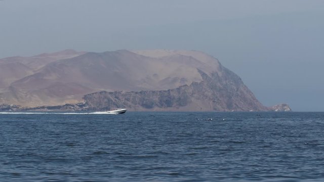 Motor boat sailing with mountain in background near Paracas Peru