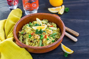 Spanish seafood paella in traditional clay pot 