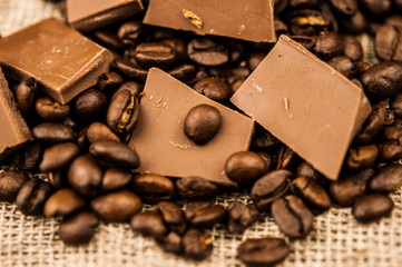 Pile of coffee beans with chocolate on burlap cloth background