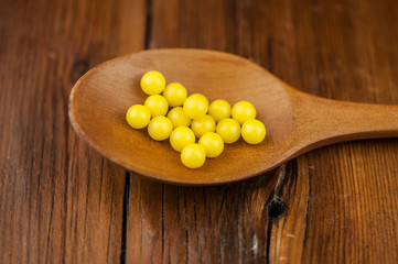 yellow drops vitamin on wood spoon