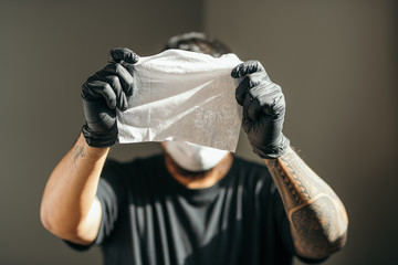 Coronavirus. Man wearing in medical protective mask and latex glove showing paper wipes in house to prevent Coronavirus, Covid-19, flu. Spray bottle. Virus and illness protection.