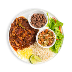 A bowl of Mexican chicken stew served with beans, rise and tomato salsa isolated on white