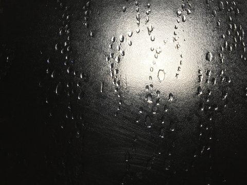 Full Frame Shot Of Raindrops On Glass Window During Monsoon