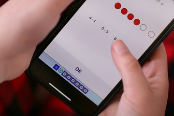 Distance Internet learning. Home based learning online. Studying at home.Children's hands with a mobile phone with a math program. School program at home during caronavirus.Online learning.