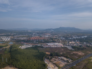 Fototapeta premium aerial view of the city around the picturesque mountains at sunrise, Kathu, Phuket