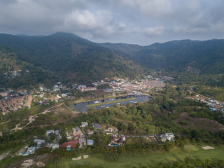 Beautiful lake located on a golf course surrounded by houses and mountains at dawn, photo from a drone. In the lake the reflection of the sky. Great background for travel and golf advertising.