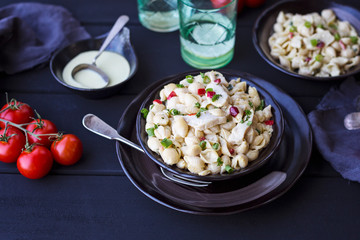 Bowl of roasted chicken and creamy pasta salad  on dark background 