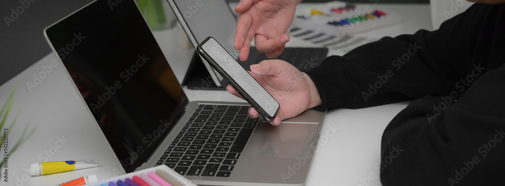 Wall mural side view of two businesswoman consulting on their work with mock-up smartphone