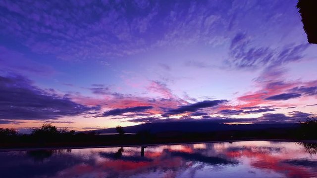 Timelapse of a spectacular sunrise in Lake Natron with the clouds reflecting in a swimming pool. Tanzania.