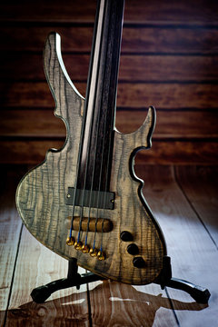 Five-string electric dark wood bass. Background for music and creativity.