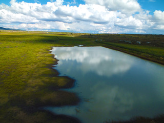 Lago en medio de un hermoso cielo azul, lago azul, lago con agua cristalina, pequeño laguna en medio de un campo