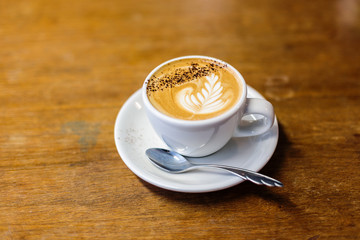 Cup of flat white coffee in colorful mug on a cafe table 