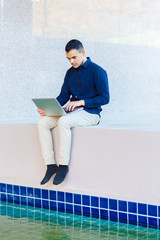 young asia business man, Happy young man working on laptop,at his working from home,Mock up copy space,Beside the pool