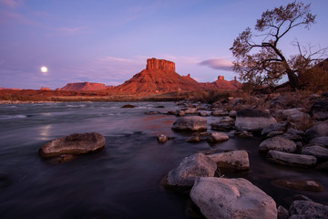 Fototapeta na wymiar Colorado river with desert landscape glowing in Utah near moab with moon