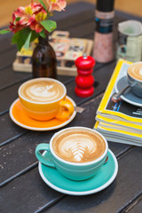 Cups of coffee in colorful mugs on a cafe table 