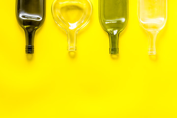 Flat lay with bottles on yellow table top-down copy space