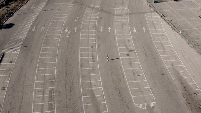 Individual person in empty parking lot, COVID-19 coronavirus lockdown, aerial view