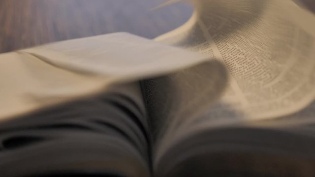 Close Up of Bible Open with Pages Blowing in Slow Motion
