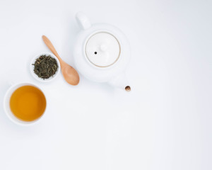cup with tea and teapot on white background, over light
