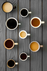 Fototapeta na wymiar Many cups of coffee on wooden desk top view