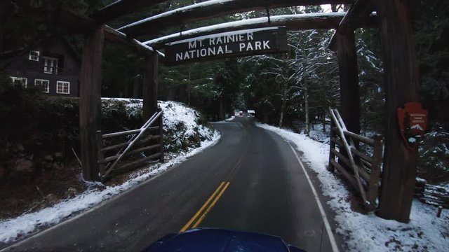 Driving Under Mt Rainier National Park Sign in Winter Snow