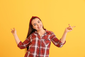 Portrait of dancing young woman on color background