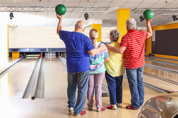 Senior people playing bowling in club