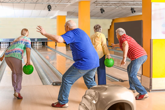 Senior People Playing Bowling In Club