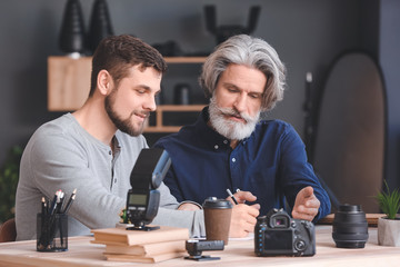 Mentor teaching young photographer in studio