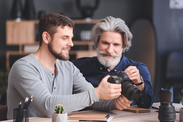 Mentor teaching young photographer in studio