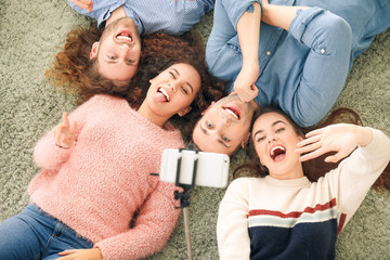 Friends taking selfie at home, top view